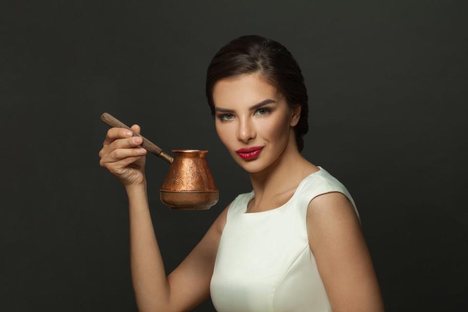 A person holding a copper pot. 