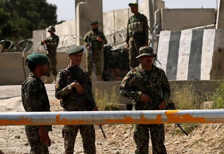 Afghan National Army (ANA) soldiers keep watch at the gate of a British-run military training academy Camp Qargha, after an Afghan military policeman fatally shot a U.S. general and wounded more than a dozen other people at a training center in Kabul August 5, 2014. REUTERS/Omar Sobhani