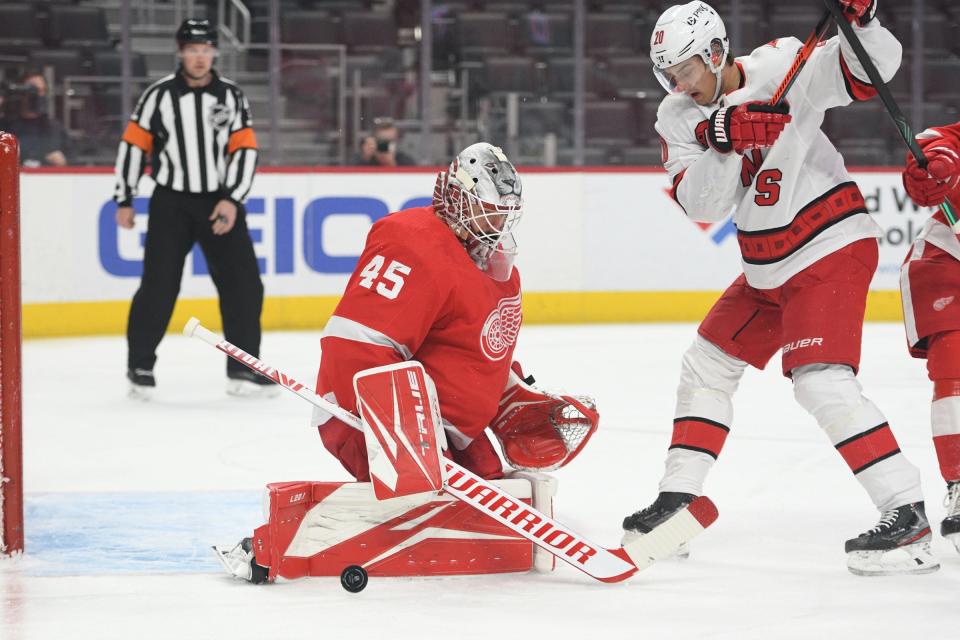 Detroit Red Wings goaltender Jonathan Bernier (45) makes a save in front of Carolina Hurricanes center Sebastian Aho (20) during the first period March 14, 2021, at Little Caesars Arena in Detroit.