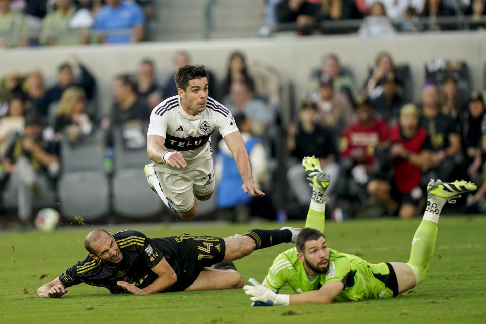 Vancouver Whitecaps forward Brian White, top watches his goal past Los Angeles FC defender Giorgio Chiellini, bottom left, and goalkeeper Maxime Crépeau during the first half of an MLS playoff soccer match Saturday, Oct. 28, 2023, in Los Angeles. (AP Photo/Ryan Sun)