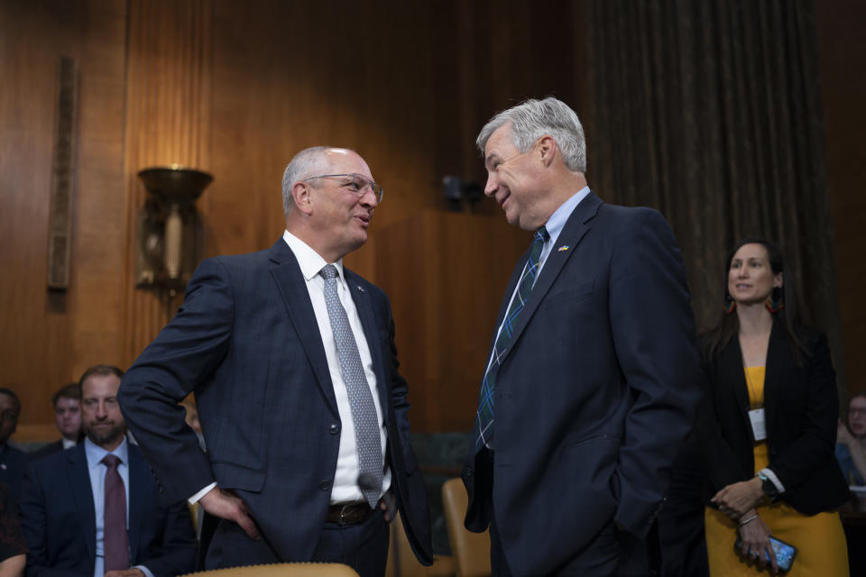 Louisiana Governor John Bel Edwards, left, is greeted by Senate Budget Committee Chairman Sheldon Whitehouse, D-R.I., before Edwards testifies on the fiscal consequences of climate change on infrastructure, at the Capitol in Washington, Wednesday, July 26, 2023. (AP Photo/J. Scott Applewhite)