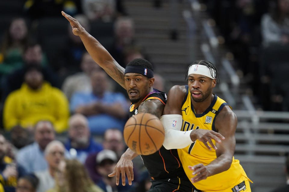 Indiana Pacers' Buddy Hield (7) makes a pass against Phoenix Suns' Bradley Beal (3) during the first half of an NBA basketball game, Friday, Jan. 26, 2024, in Indianapolis. (AP Photo/Darron Cummings)