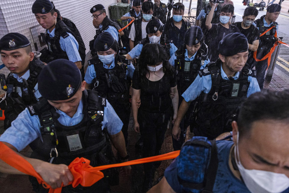 Police officers take away a member of the public in the Causeway Bay area on the eve 34th anniversary of China's Tiananmen Square massacre in Hong Kong, Saturday, June 3, 2023. (AP Photo/Louise Delmotte)