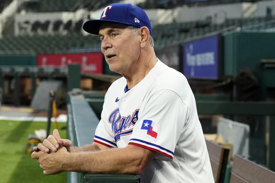 FILE - New Texas Rangers baseball team manager Bruce Bochy poses for photos in the dugout at Globe Life Field after a news conference in Arlington, Texas, Oct. 24, 2022. (AP Photo/Tony Gutierrez, File)