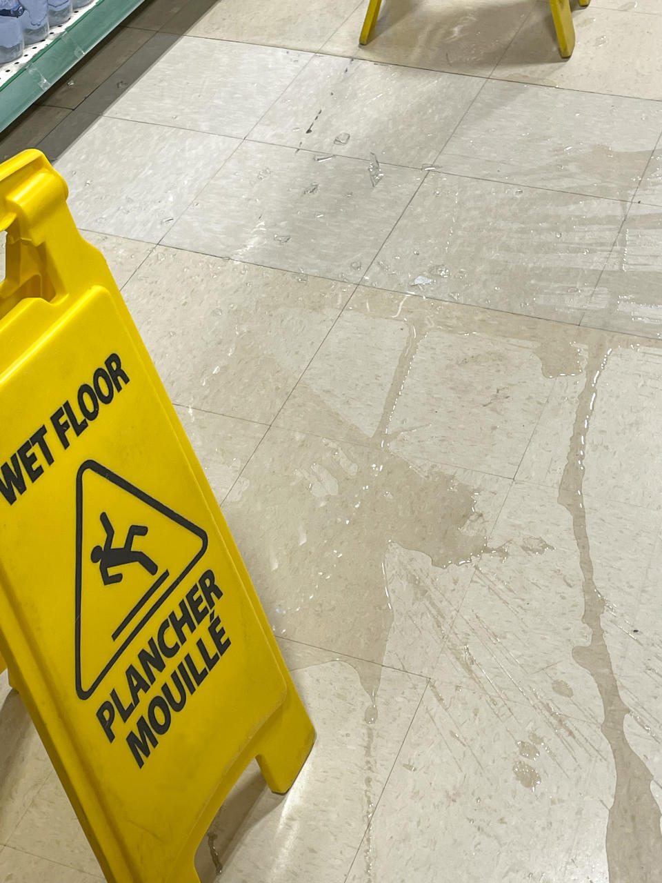 Water spilled on a store floor with a wet floor sign. Source: Getty Images