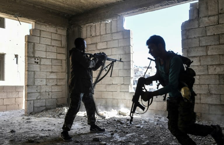 Members of the Syrian Democratic Forces fire their weapons during a battle against Islamic State group jihadists in Raqa on September 28