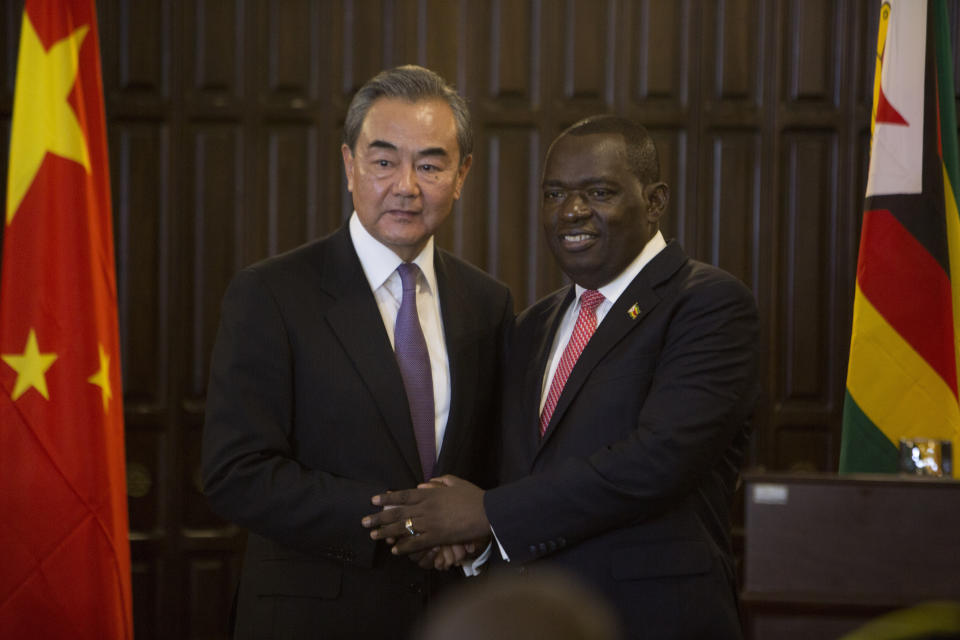 China's Foreign Minister Wangi Yi, left, greets Zimbabwe's Foreign Minister Sibusiso Moyo after a joint press conference in Harare, Zimbabwe, Sunday, Jan, 12, 2020. Wangi Yi is in Zimbabwe as part of a five nation tour of Africa that seeks to promote the Asian economic and political interests on the continent. (AP Photo/Tsvangirayi Mukwazhi)