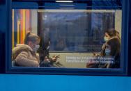 Passengers wear face masks as they sit in a subway in Frankfurt, Germany, Wednesday, Oct. 28, 2020. (AP Photo/Michael Probst)