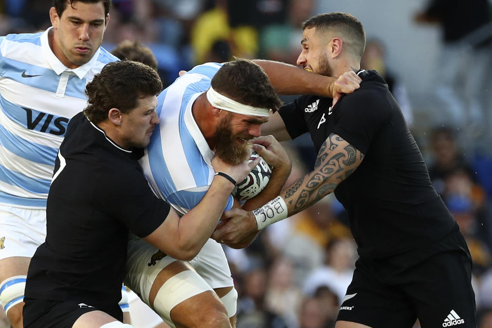 Argentina's Marcos Kremer, second right, charges into the New Zealand defense of Dalton Papalii and TJ Perenara, right, during their Rugby Championship match on Sunday, Sept. 12, 2021, on the Gold Coast, Australia. (AP Photo/Tertius Pickard)