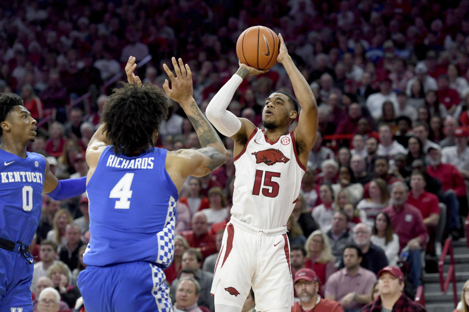 Arkansas guard Mason Jones (15) pulls up to shoot over Kentucky defenders Nick Richards (4) and Ashton Hagans (0) during the first half of an NCAA college basketball game, Saturday, Jan. 18, 2020, in Fayetteville, Ark. (AP Photo/Michael Woods)