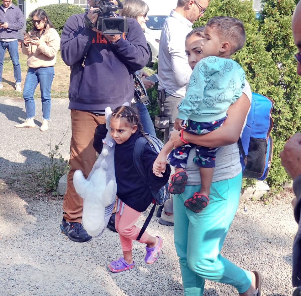 Venezuelan migrants make their way to a bus on Friday that will bring them from St. Andrews Episcopal Church in Edgartown to Vineyard Haven and the ferry to Woods Hole. The group of about 50 people was brought to Joint Base Cape Cod.