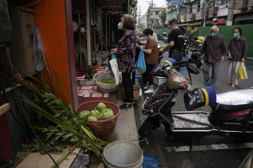 Residents buy vegetables at a store Thursday, June 2, 2022, in Shanghai. Traffic, pedestrians and joggers reappeared on the streets of Shanghai on Wednesday as China's largest city began returning to normalcy amid the easing of a strict two-month COVID-19 lockdown that has drawn unusual protests over its heavy-handed implementation. (AP Photo/Ng Han Guan)