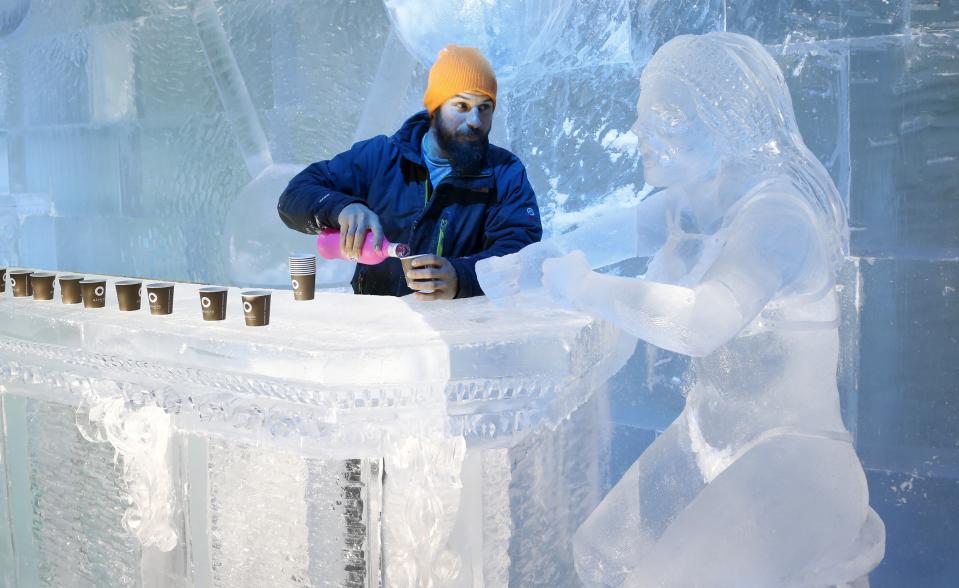 Sculptor Jonathan Bouchard of Canada poses near a sculpture at the ice bar of the Brussels Ice Magic Festival December 17, 2013. Some 20 artists from all over the world made sculptures out of 420 tonnes of ice depicting characters from comic strips. The festival will open on December 20 and will end on February 9, 2014. REUTERS/Francois Lenoir (BELGIUM - Tags: ENTERTAINMENT SOCIETY)