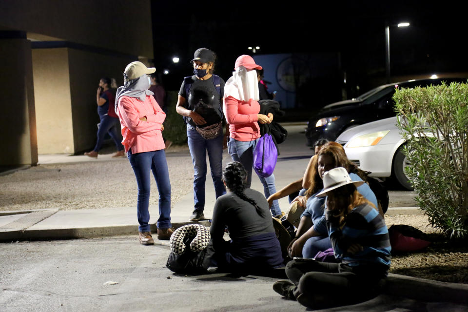 Migrant and seasonal day laborers gather outside a Chase parking lot to wait for buses that will take them to work on agricultural fields several miles away. (Christine Romo / NBC News)