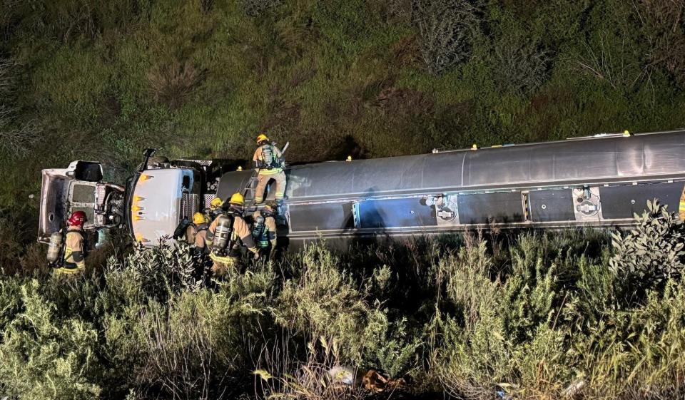 Firefighters work at the scene of a fuel truck crash along the 15 Freeway in the Cajon Pass on Tuesday, April 2, 2024.