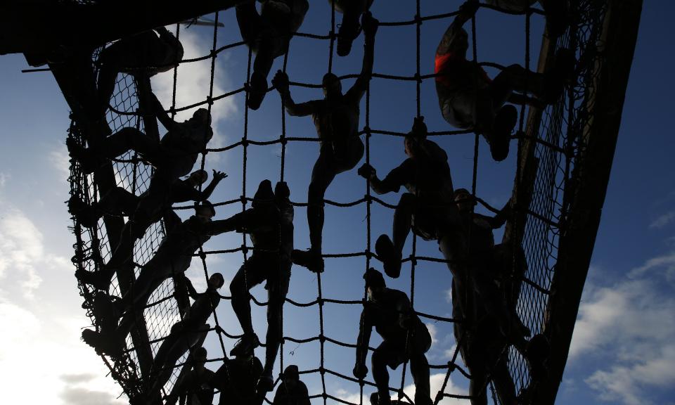 Competitors cross a cargo net during the Tough Guy event in Perton, central England
