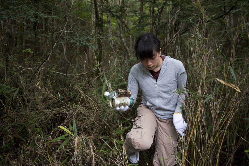 In this Thursday, Aug. 29, 2013 photo, a Japanese student collects garbage on the slopes of Mount Fuji in Japan during a school outing to learn about the mountain environment. The Japanese cheered the recent recognition of Mount Fuji as a UNESCO World heritage site, though many worry that the status may worsen the damage to the environment from the tens of thousands who visit the peak each year. (AP Photo/David Guttenfelder)