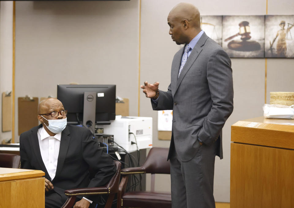 Defense attorney Kobby Warren, right, asks his client Billy Chemirmir if he understands the motions and language being sent to the jury after one juror is hanging up the deliberations in his capital murder trial at the Frank Crowley Courts Building in Dallas, Texas, Friday, Nov. 19, 2021. Chemirmir, 48, faces life in prison without parole if convicted of capital murder for smothering Lu Thi Harris, 81, and stealing her jewelry. He is accused of killing at least 18 women in Dallas and Collin counties. (Tom Fox/The Dallas Morning News via AP, Pool)