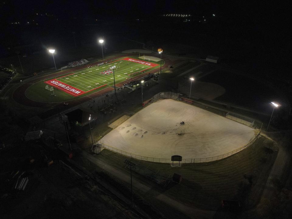 A football field, top, and baseball field under construction are lit up at Whitewater High School Friday, Oct. 1, 2021, in Whitewater, Wis. A growing number of school districts in the U.S. are using federal pandemic funding on athletics projects. When school officials at Whitewater learned they would be getting $2 million in pandemic relief this year, they decided to set most of it aside to cover costs from their current budget, freeing up $1.6 million in local funding that’s being used to build new synthetic turf fields for football, baseball and softball. (AP Photo/Morry Gash)