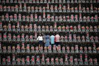 <p>In this picture taken on August 13, 2018 a family pays respects in front of jizo statues in Jizoji Buddhist Temple in Oganomachi, Saitama prefecture, for the souls of unborn children and those who died at a young age, during the Obon prayers period. (Photo by BEHROUZ MEHRI/AFP/Getty Images) </p>