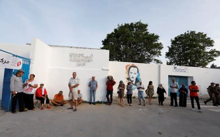 People wait to cast their vote outside a polling station during presidential election in Tunis