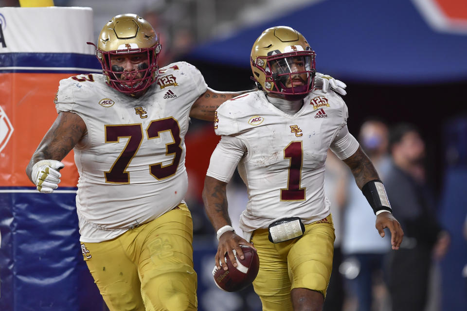 Boston College quarterback Thomas Castellanos, right, celebrates with offensive lineman Christian Mahogany after scoring against Syracuse during the second half of an NCAA college football game in Syracuse, N.Y., Friday, Nov. 3, 2023. (AP Photo/Adrian Kraus)