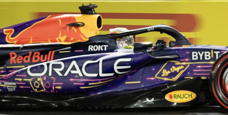 Close-up of Formula One champion Max Verstappen in his purple, yellow and orange Red Bull Racing car.