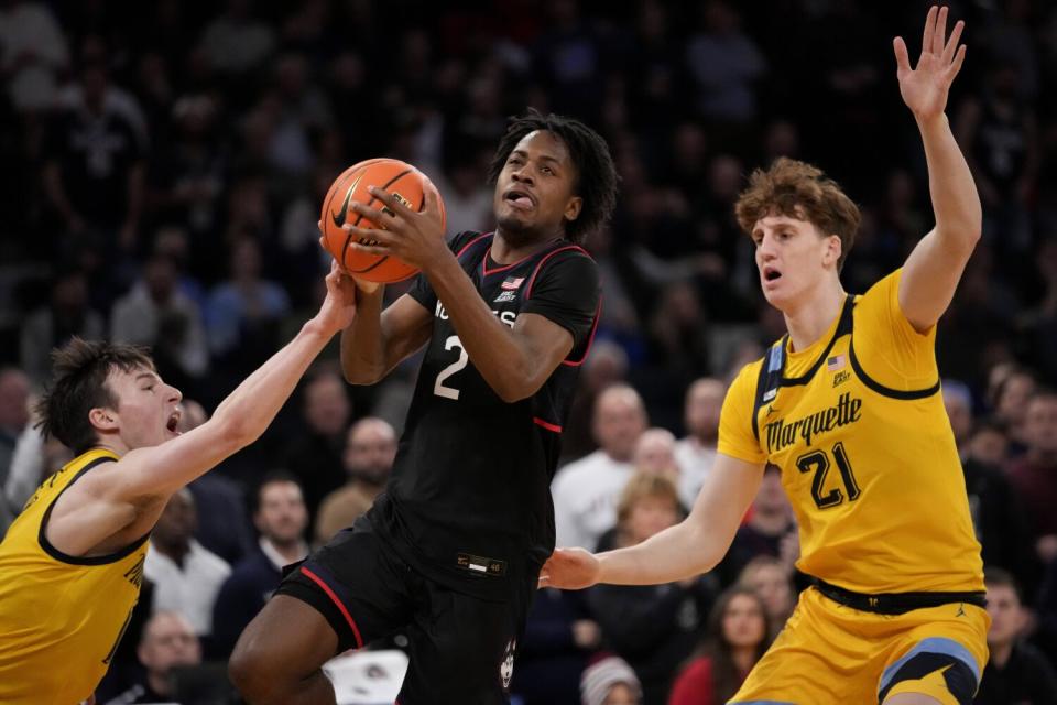 Connecticut's Tristen Newton shoots past Marquette's Ben Gold.