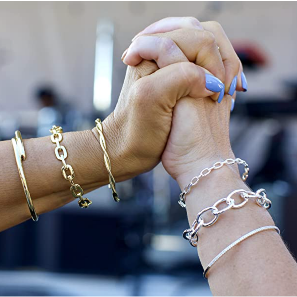 Two models wearing the gold and silver Maya J Harmony Trio Bracelets fromAmazon