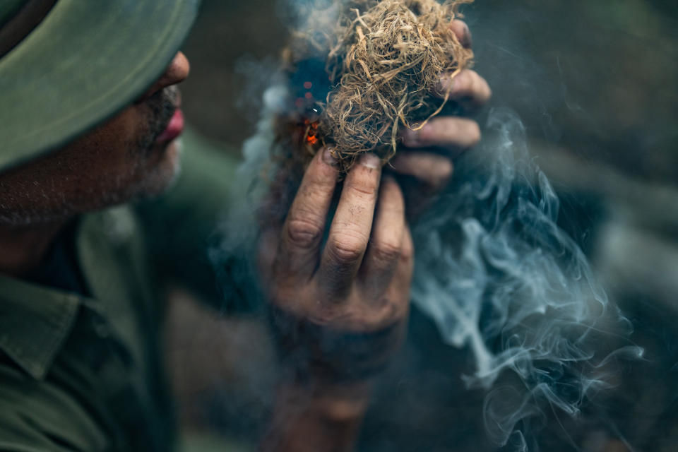 Shane Hobel puts an ember into cambium and blows on it to start a fire at the Mountain Scout Survival School. (Michael Rubenstein / for NBC News)