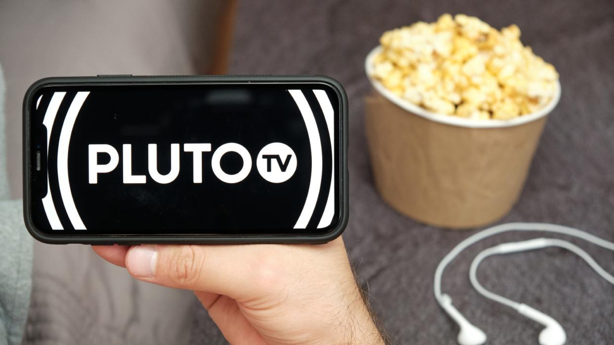  Pluto TV on a phone with popcorn nearby. 