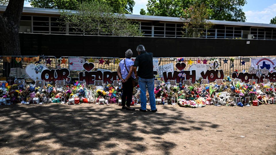People visit a makeshift memorial to the victims of the shooting at Robb Elementary in Uvalde, on June 30.