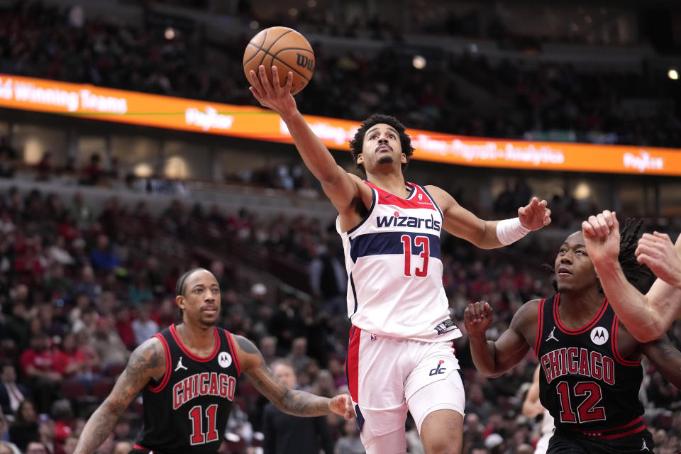 Washington Wizards' Jordan Poole drives to the basket past Chicago Bulls' DeMar DeRozan (11) and Ayo Dosunmu during the first half of an NBA basketball game Monday, March 25, 2024, in Chicago. (AP Photo/Charles Rex Arbogast)
