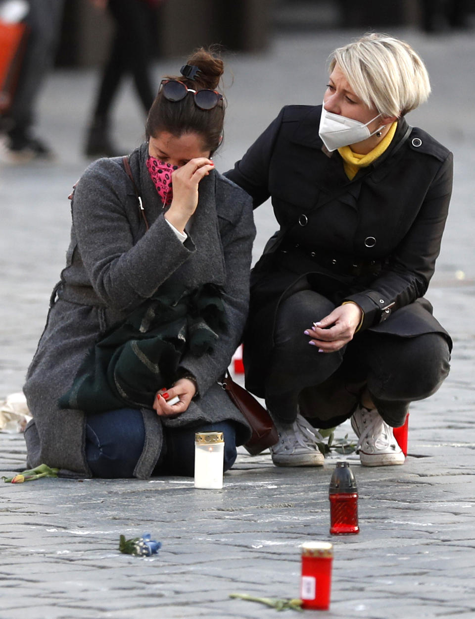 People pay respect to victims of COVID-19 at a spontaneous memorial place set at the Old Town Square in Prague, Czech Republic, Monday, March 29, 2021. The coronavirus pandemic is unleashing enormous suffering as infection rates rise across central Europe even as the Czech Republic and Slovakia, recently among the worst-hit areas in the world, are finally seeing some improvements following tight lockdowns. (AP Photo/Petr David Josek)