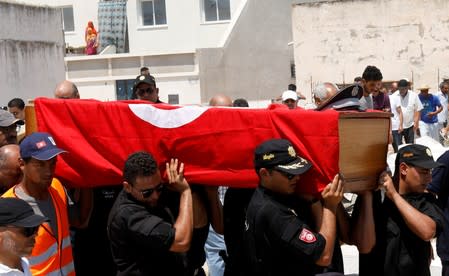 Police officers carry the coffin of their comrade during his funeral in Sidi Hassine