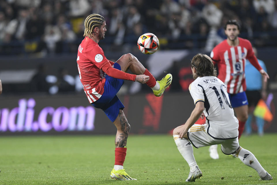 Real Madrid's Luka Modric, right, and Atletico Madrid's Rodrigo De Paul fight for the ball during the Spanish Super Cup semi final soccer match at Al Awal Park Stadium in Riyadh, Saudi Arabia, Wednesday, Jan. 10, 2024. (AP Photo)