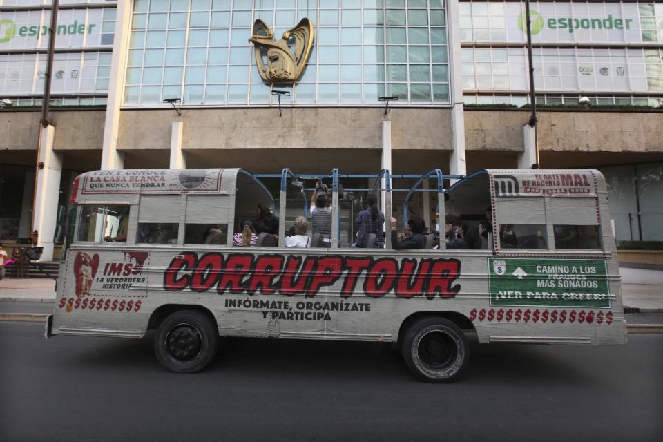 The tour bus Corruptour runs through the streets in Mexico City, Sunday, Feb. 5, 2017. This is the newest addition to the ubiquitous open-air tour buses that crisscross Mexico City each day: The Corruptour, which instead of taking folks to historic plazas and churches, shines an unflattering spotlight on the murky world of graft. They also engage with bemused bystanders along the route, coaxing pedestrians and taxi drivers to join in chanting “No more corruption!” (AP Photo/Marco Ugarte)