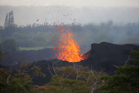 Lava erupts on the outskirts of Pahoa during ongoing eruptions of the Kilauea Volcano in Hawaii, U.S., May 19, 2018. REUTERS/Terray Sylvester