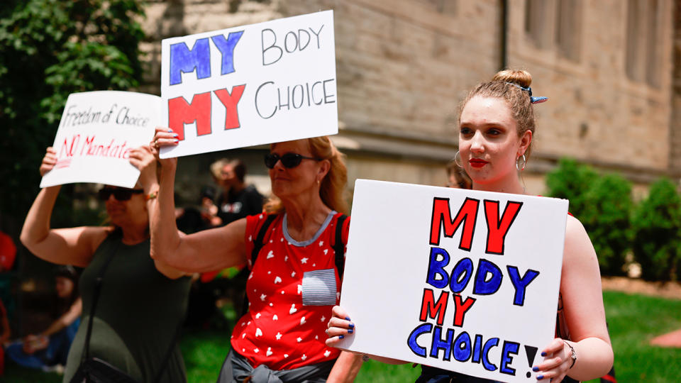 Protesters holding placards gather at Indiana University's Sample Gates during the demonstration in Bloomington, Indiana on June 10, 2021. Anti-vaxxers and anti-maskers gathered at Indiana University's Sample Gates to protest against mandatory Covid vaccinations IU is requiring for students, staff and faculty during the upcoming fall semester. (Jeremy Hogan/SOPA Images/LightRocket via Getty Images)