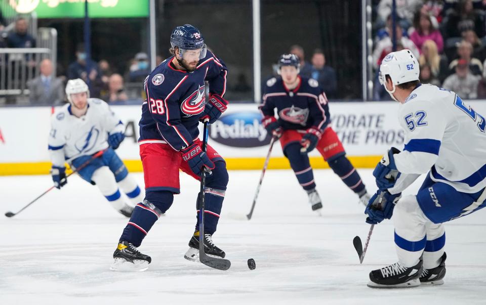 Columbus Blue Jackets right wing Oliver Bjorkstrand (28) brings the puck into the offensive zone around Tampa Bay Lightning defenseman Cal Foote (52) during the first period of the NHL game at Nationwide Arena in Columbus on April 28, 2022.