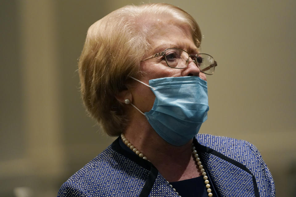 Although face masked, Highland Colony Baptist Church greeter Joy Sartain, prays during services in Ridgeland, Miss., Nov. 29, 2020. The church practices covid protocols by allowing families to sit spaced out from others, separating older and more vulnerable members in the Worship Center and providing sanitizer and masks at the entrance. (AP Photo/Rogelio V. Solis)