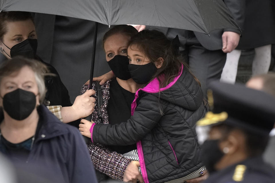 Shannon Terranova, center left, wife of the late U.S. Capitol Police officer William "Billy" Evans, carries her daughter Abigail Evans, 7, while departing St. Stanislaus Kostka Church with Evan's mother Janice Evans, left, following a funeral Mass for her husband, in Adams, Mass., Thursday, April 15, 2021. Evans, a member of the U.S. Capitol Police, was killed on Friday, April 2, when a driver slammed his car into a checkpoint he was guarding at the Capitol. (AP Photo/Steven Senne)