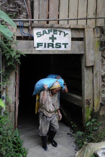 In this photo taken in 2011, a miner carries a sack load of gold ore as he emerges from a deep shaft on the Philippines' "golden mountain", at the gold rush site of Mount Diwata. A Philippine government bid to take a greater share of mining revenues amid the global commodities boom has set off a storm of debate, with industry mounting an intense campaign to knock it down