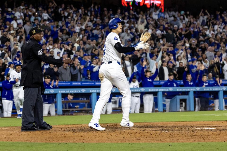 Dodgers-ster Shohei Ohtani (17) klapt richting teamgenoot Will Smith op het eerste honk na te hebben gescoord op zijn treffer vrijdagavond.