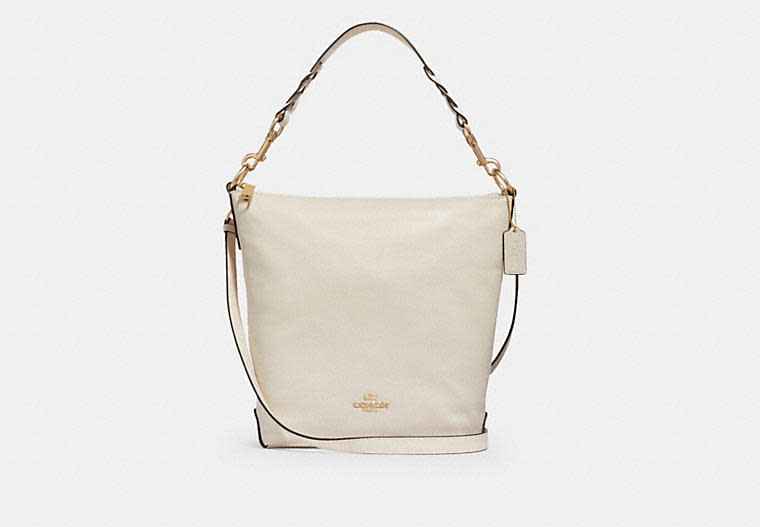 Product photo of the Abby Duffle shoulder bag in beige with gold hardware. Image via Coach Outlet.