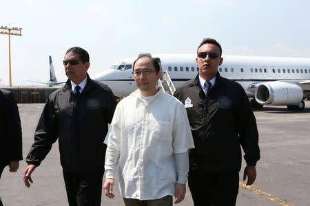 Zhenli Ye Gon, a businessman accused of working with drug cartels, is escorted by Interpol agents after arriving from the United States on a extradition flight in a hangar belonging to the office of the Attorney General in Mexico City, Mexico, October 18, 2016. REUTERS/PGR - Attorney General's Office/Handout via Reuters