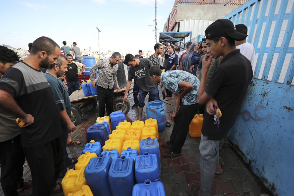 Palestinians collect water in Nuseirat camp in the central Gaza Strip during ongoing Israeli bombardment on Tuesday, Oct. 17, 2023. (AP Photo/Ali Mohmoud)