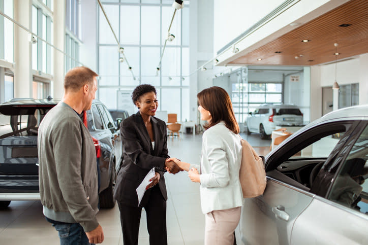 A woman selling a couple a car