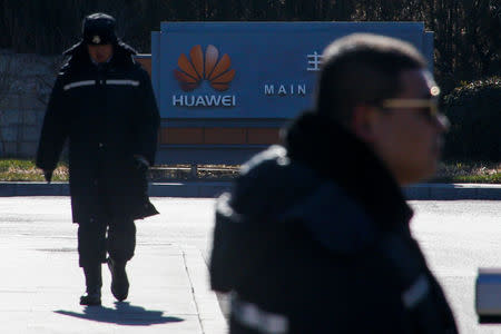 Security officers guard the gate to the compound of the Huawei office in Beijing, December 6, 2018. REUTERS/Thomas Peter