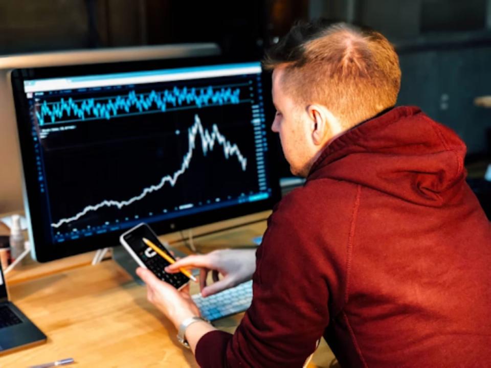 Man looking at trading charts on a computer